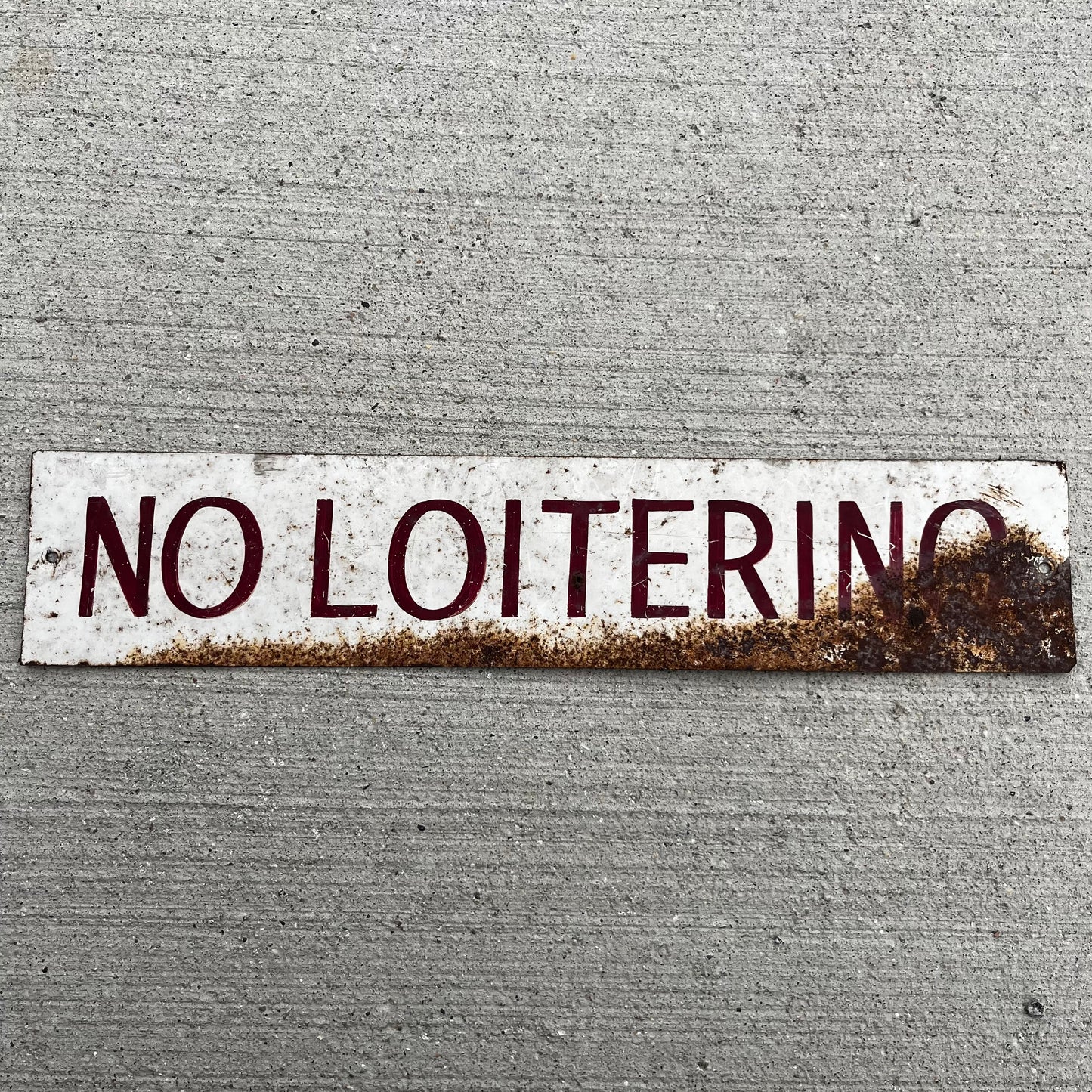 Vintage hand painted “No Loitering” tin sign.