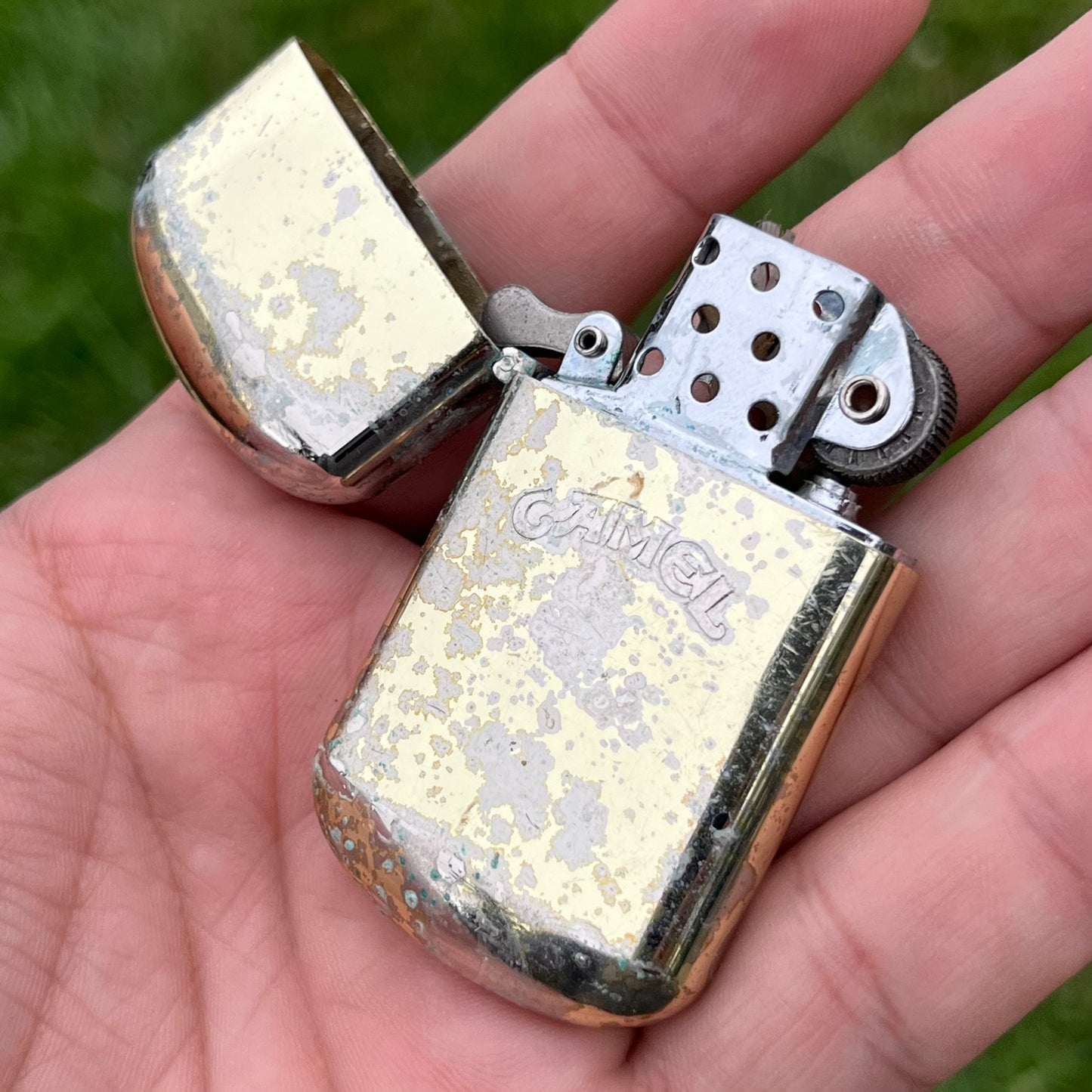 Vintage weathered Camel flip lighter.