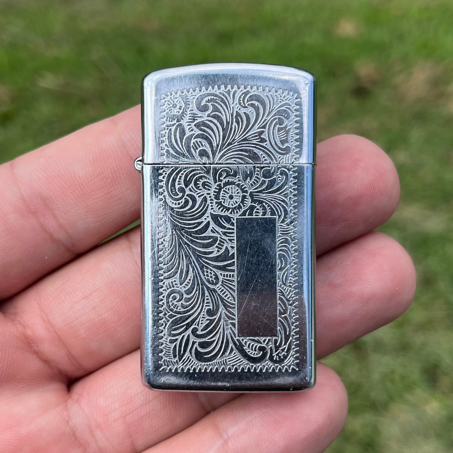 1991 Ornate Zippo flip lighter.