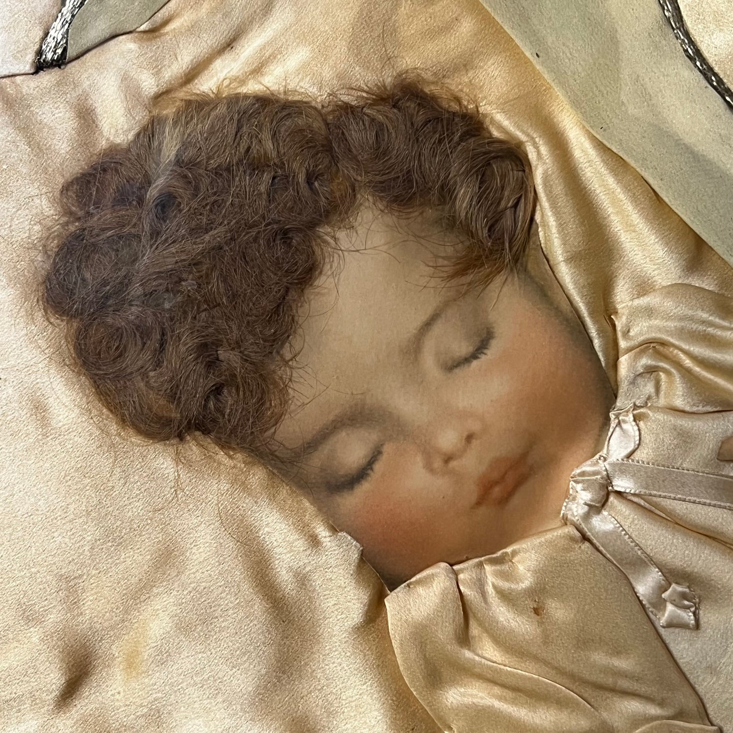 Early 1900s Sleeping baby portrait made with real hair and silk.