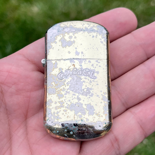 Vintage weathered Camel flip lighter.