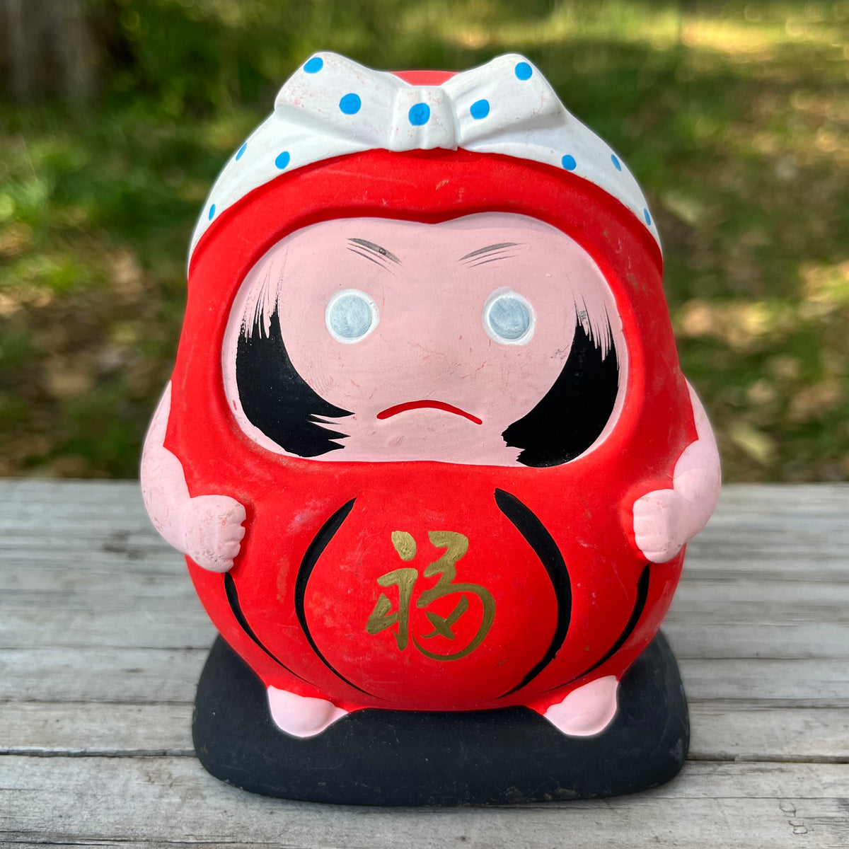 Vintage clay Hachimaki Daruma coin bank.