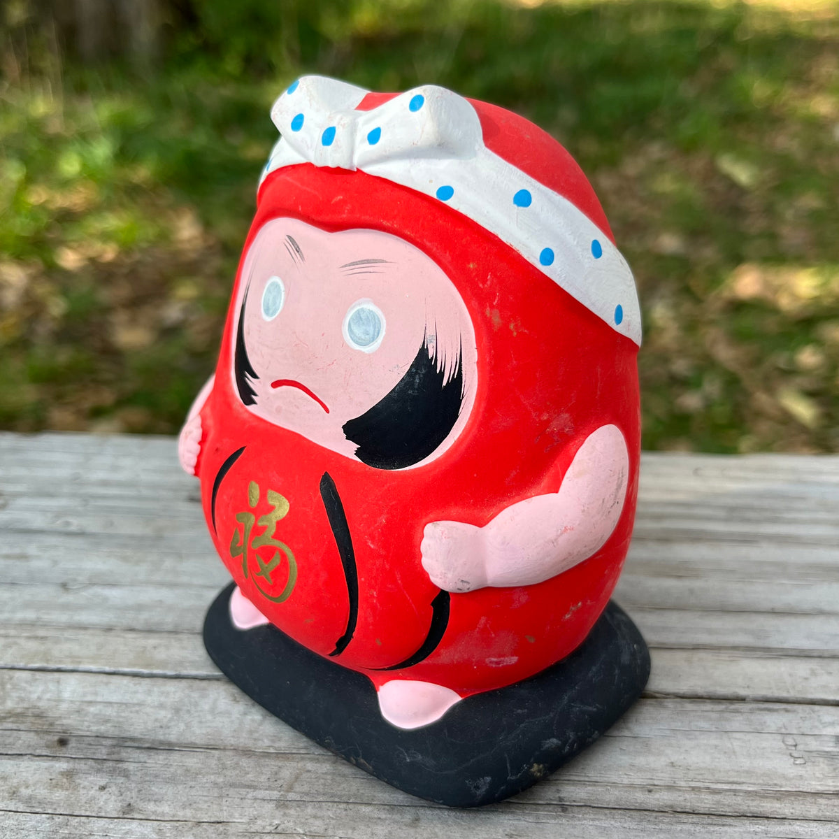 Vintage clay Hachimaki Daruma coin bank.