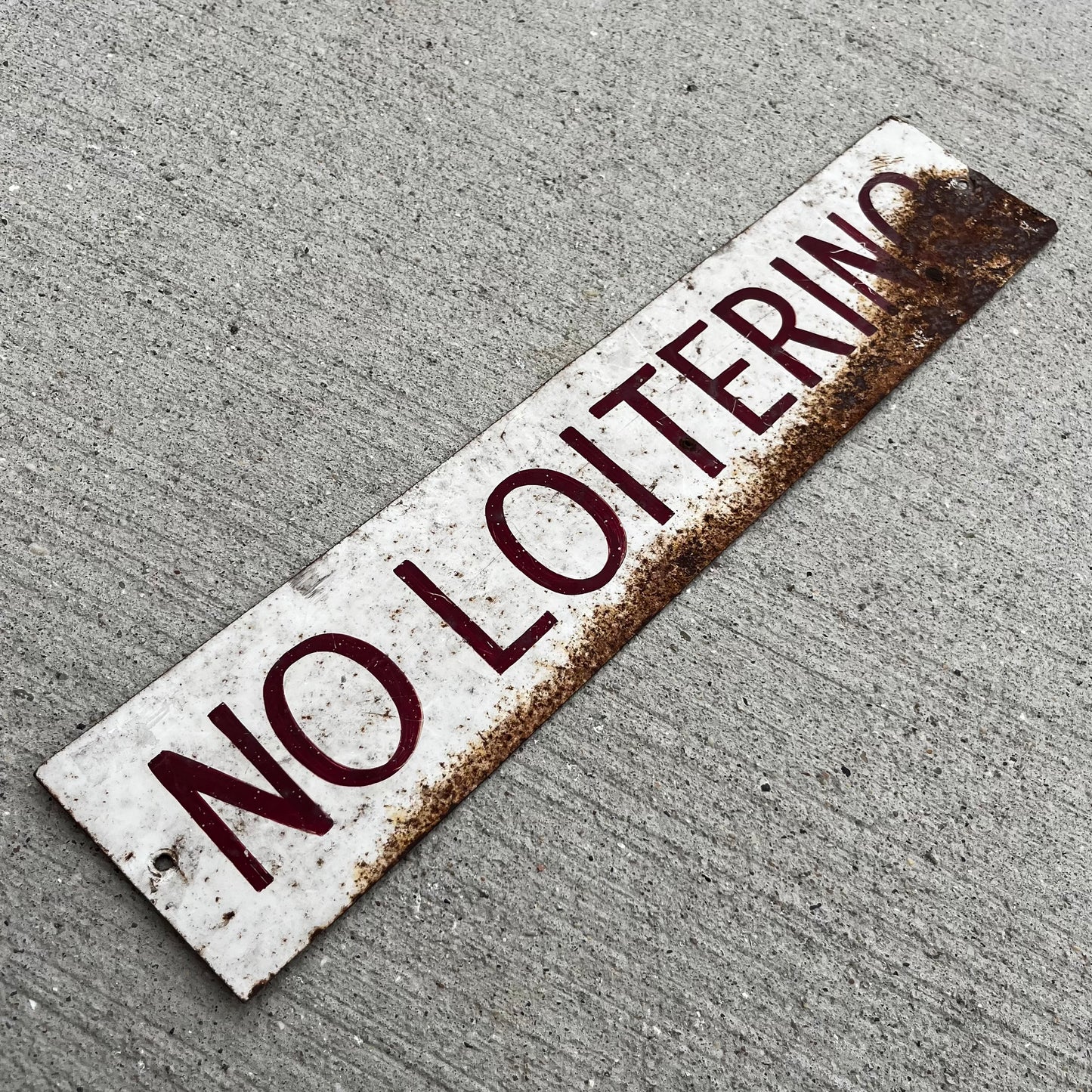 Vintage hand painted “No Loitering” tin sign.