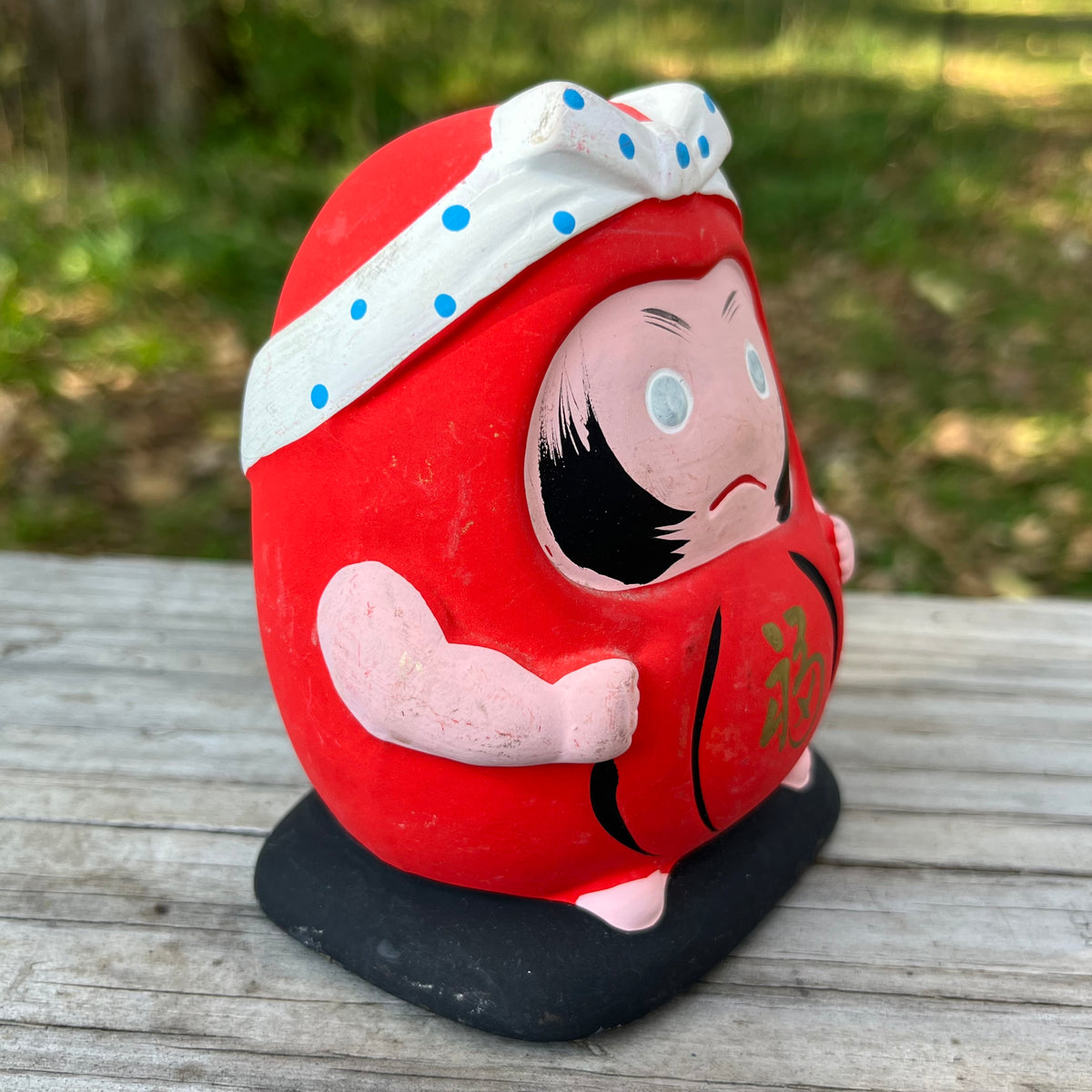 Vintage clay Hachimaki Daruma coin bank.